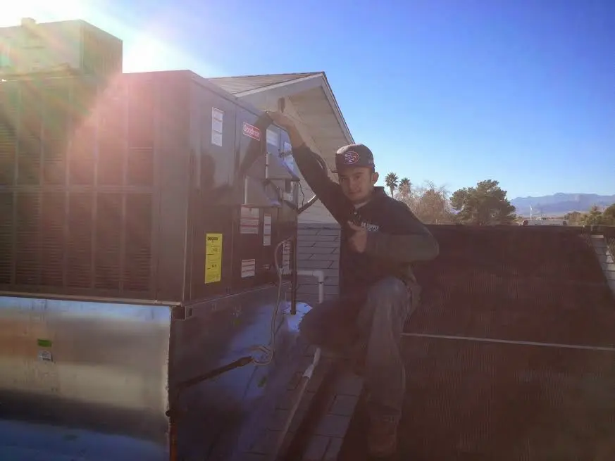 HVAC technician performing AC Tune-Up on a rooftop unit in Evergreen Park